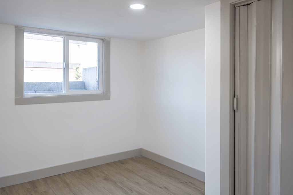 A room with a window and a closed door.