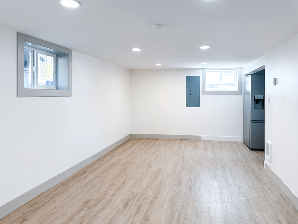 A room with wooden flooring and a window.