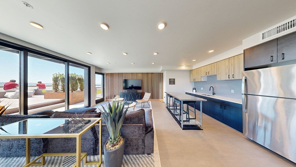 the living room and kitchen of a modern home with a view of the ocean