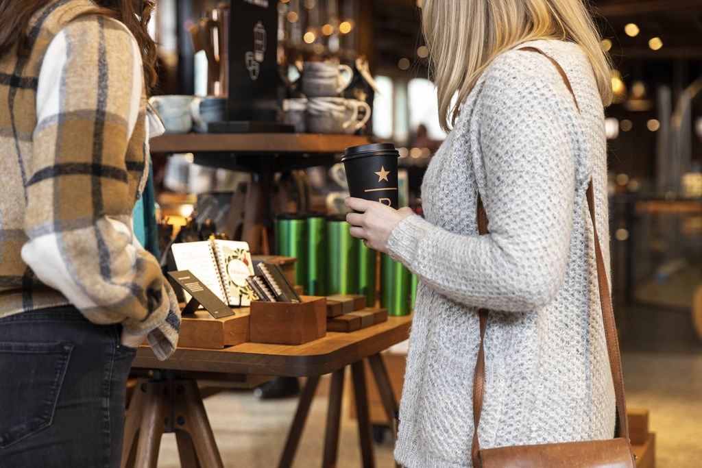 a woman holding a cup of coffee in a market