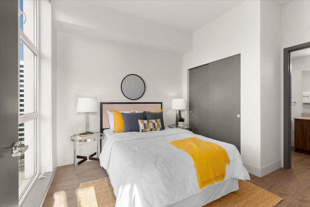 a bedroom with a bed and a large window