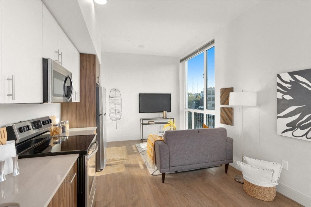 a living room with a couch and a tv in front of a window