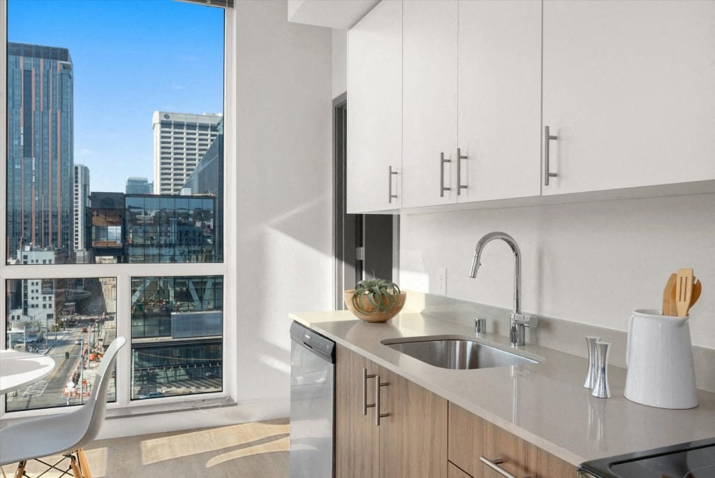 a kitchen with a sink and a window overlooking a city