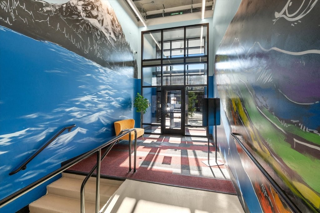 a lobby with a large mural of the ocean and stairs