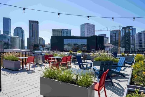 a roof top patio with chairs and tables and a view of the city