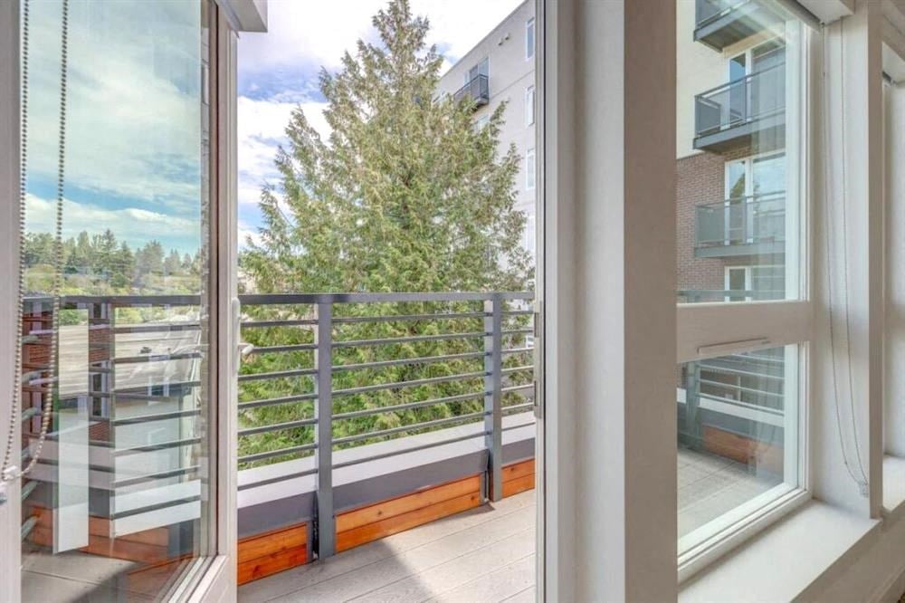 a balcony with a view of a tree and some buildings