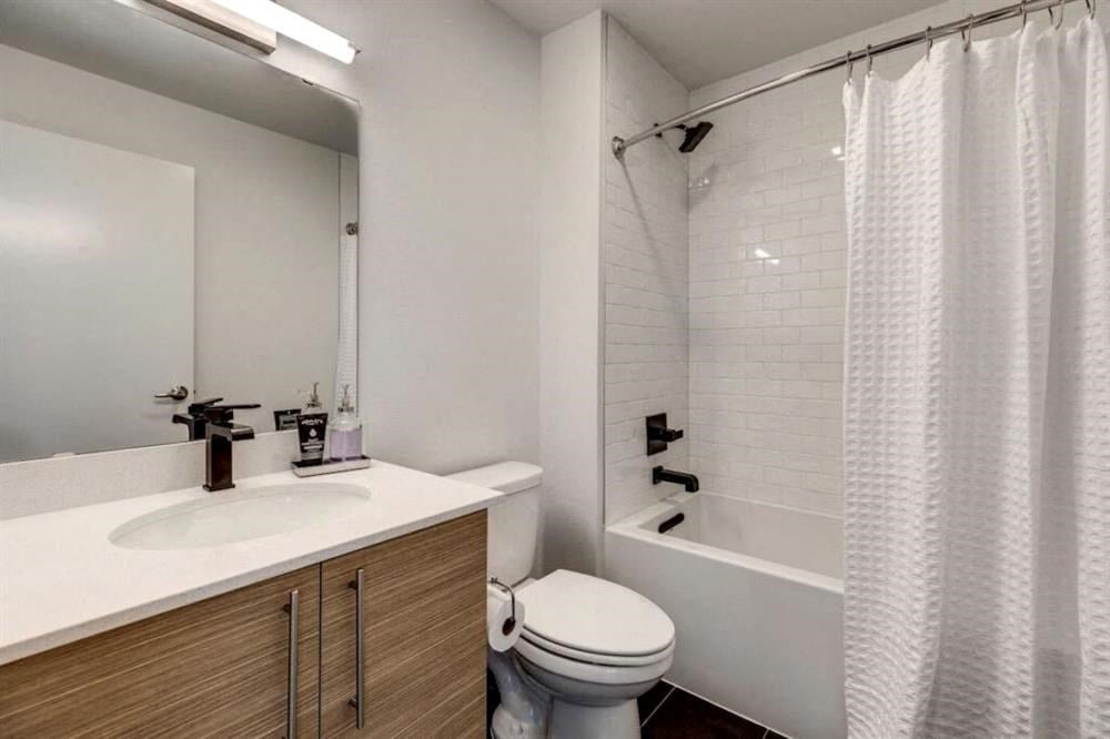 a bathroom with a toilet and a tub and a sink