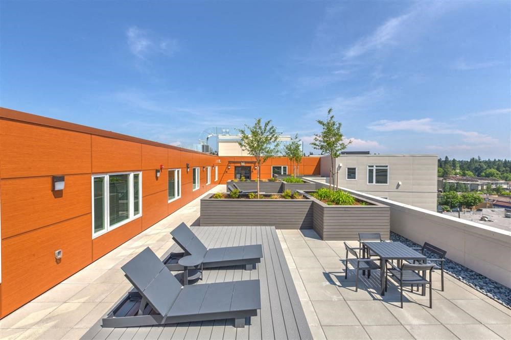 a rooftop terrace with tables and chairs on a roof