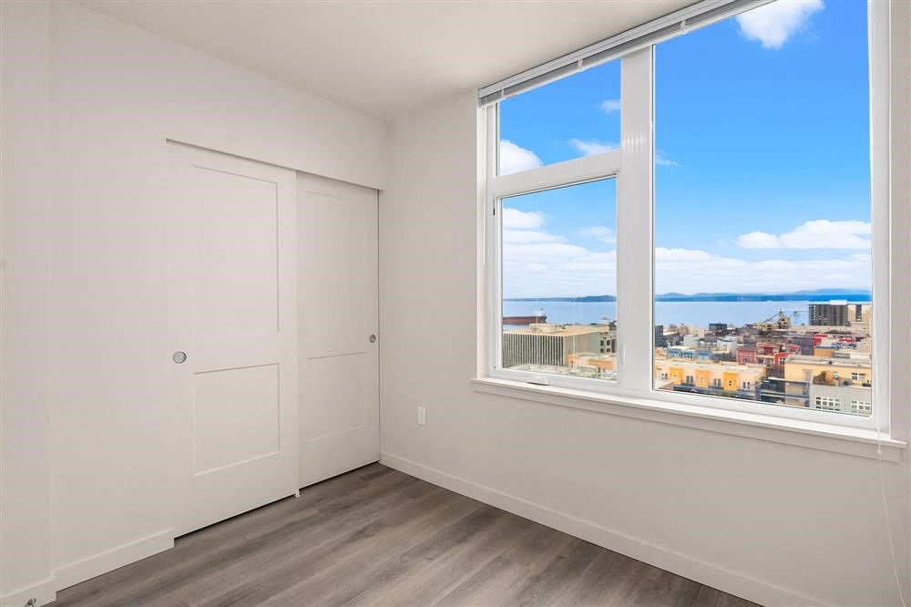 a bedroom with a large window and a view of the ocean
