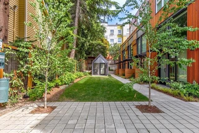 a backyard with a green lawn and some buildings
