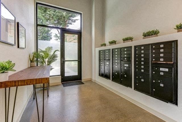 a room with a desk and a large window and a filing cabinet