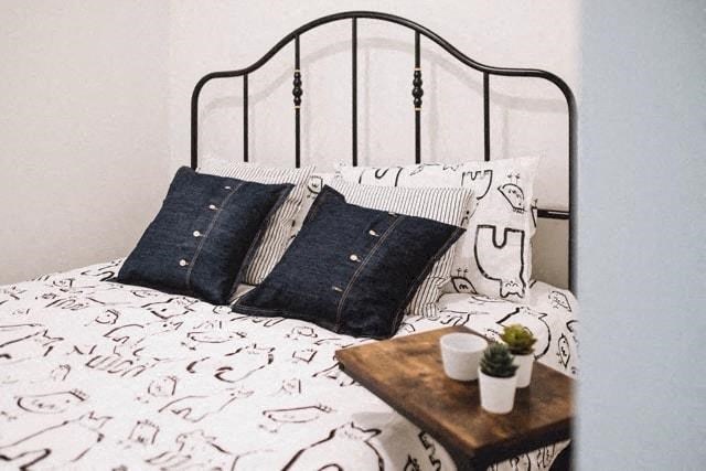 a bed with pillows and a table on top of it