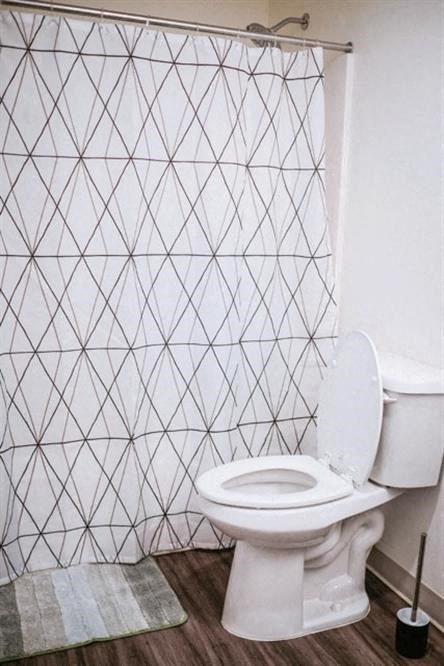 a bathroom with a toilet and a shower curtain