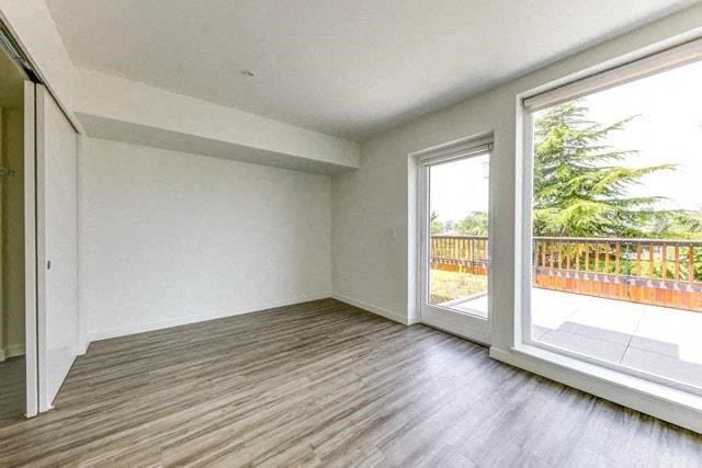 an empty living room with a large window and wooden floors