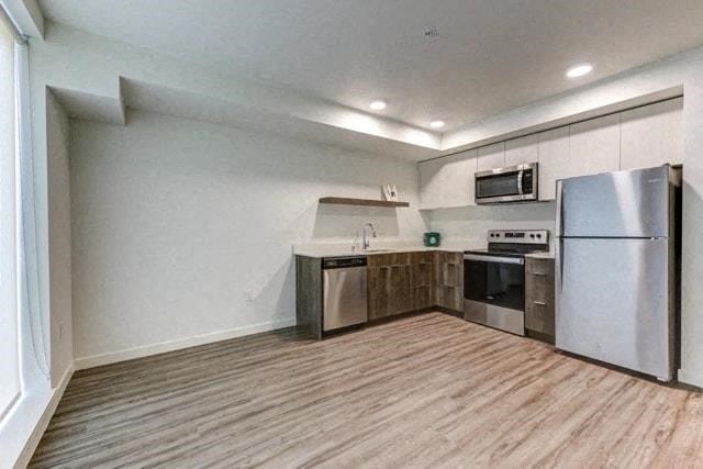 a kitchen with stainless steel appliances and a wooden floor