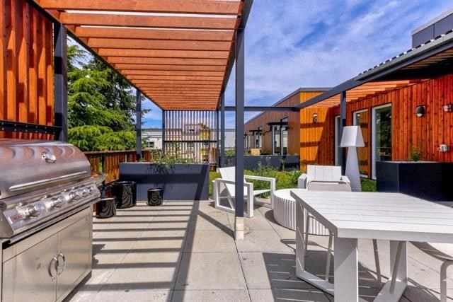 a patio with a barbecue grill and a table and chairs