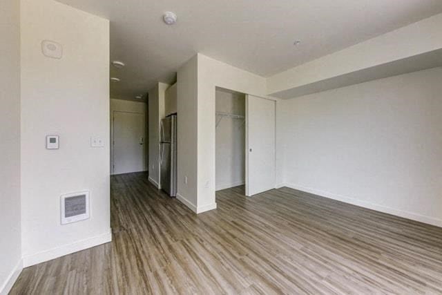 an empty living room with white walls and wood floors
