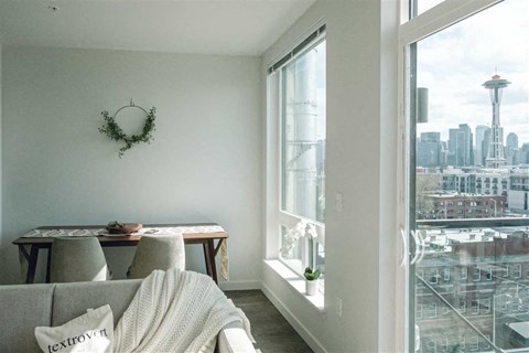 a living room with a view of the city and a couch and a table