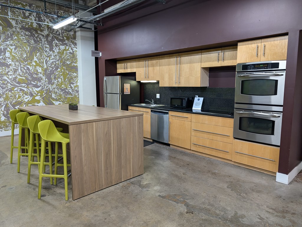 a kitchen with wooden cabinets and a table with yellow chairs