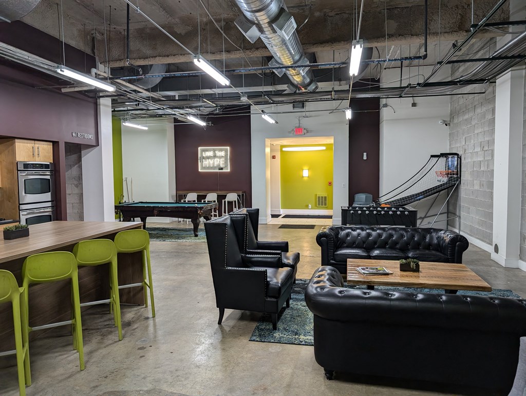 a living room with couches and chairs and a pool table