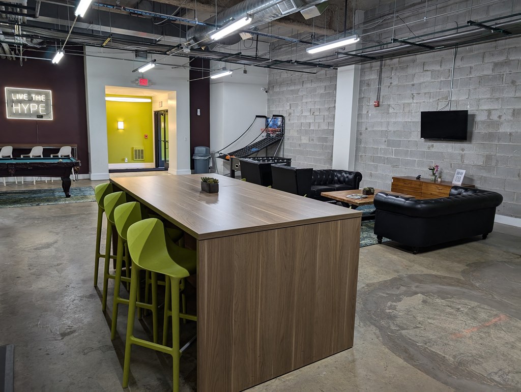 a communal table and seating area in a room with a pool table