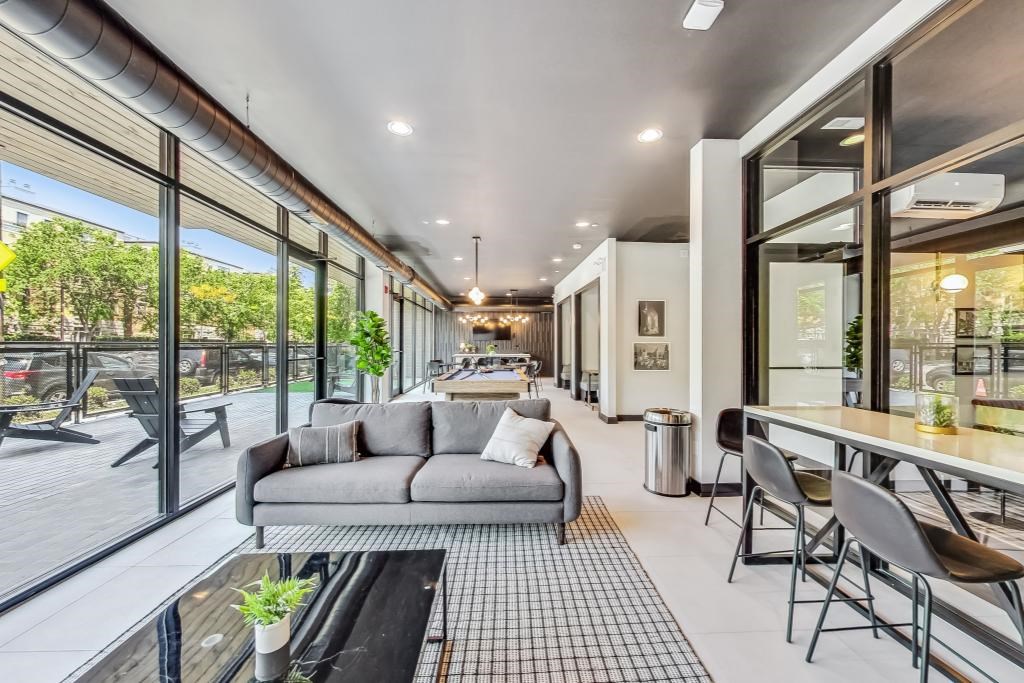 A modern living room with a grey sofa and a glass table.