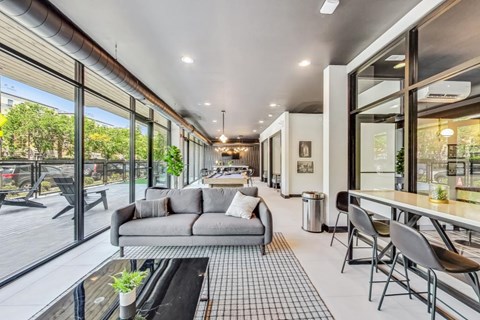 A modern living room with a grey sofa and a glass table.