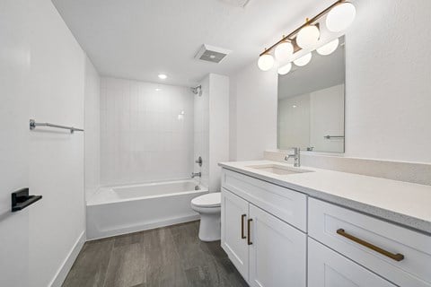 A white bathroom with a tub, toilet, and sink.