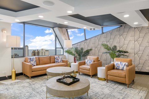 a lobby with couches and a table in front of a window