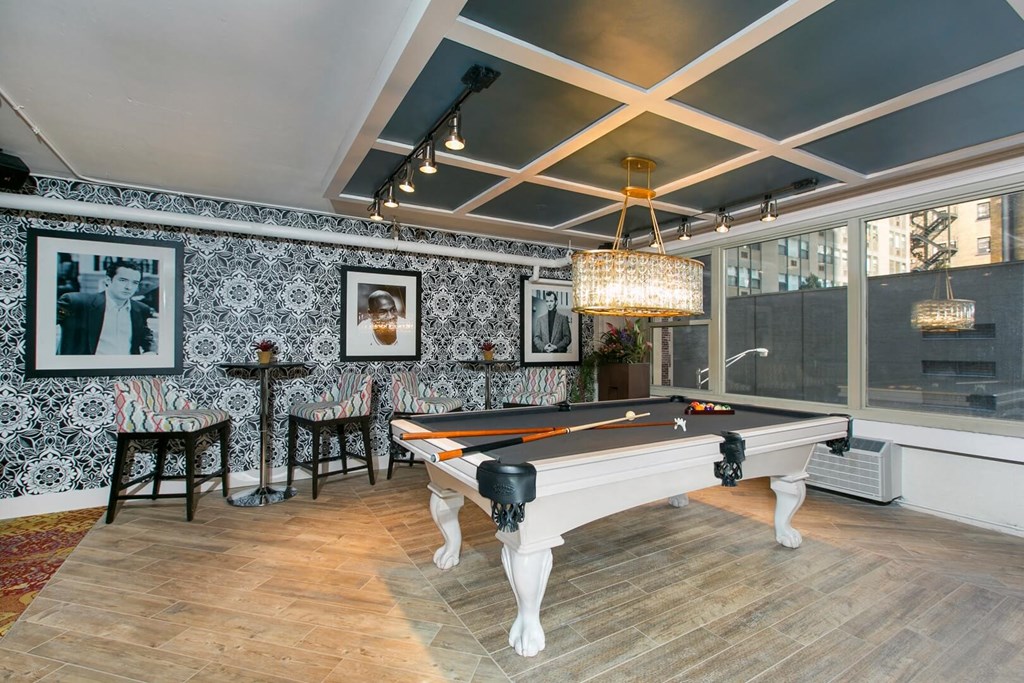 the pool room has a chandelier and a view of the city