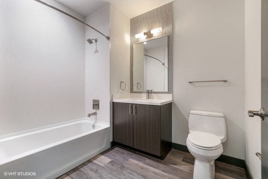 a bathroom with a toilet and a sink and a bath tub