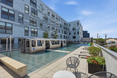 A pool area with chairs and a train-like structure.