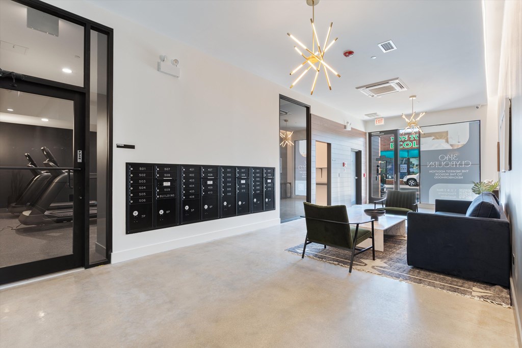 A modern office lobby with a black reception desk and a glass door.