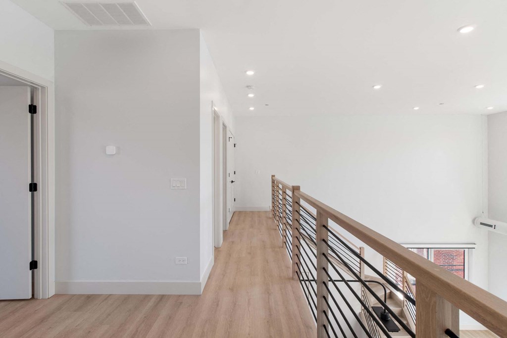 a long hallway with white walls and wood floors
