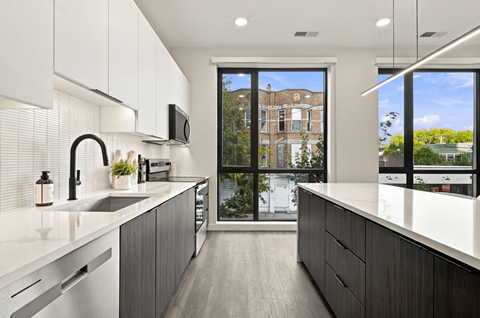 A modern kitchen with a view of a building outside the window.