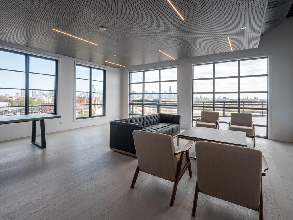 a living room with a couch table and chairs and large windows