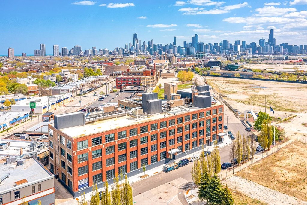 an aerial view of a building with a city skyline in the background