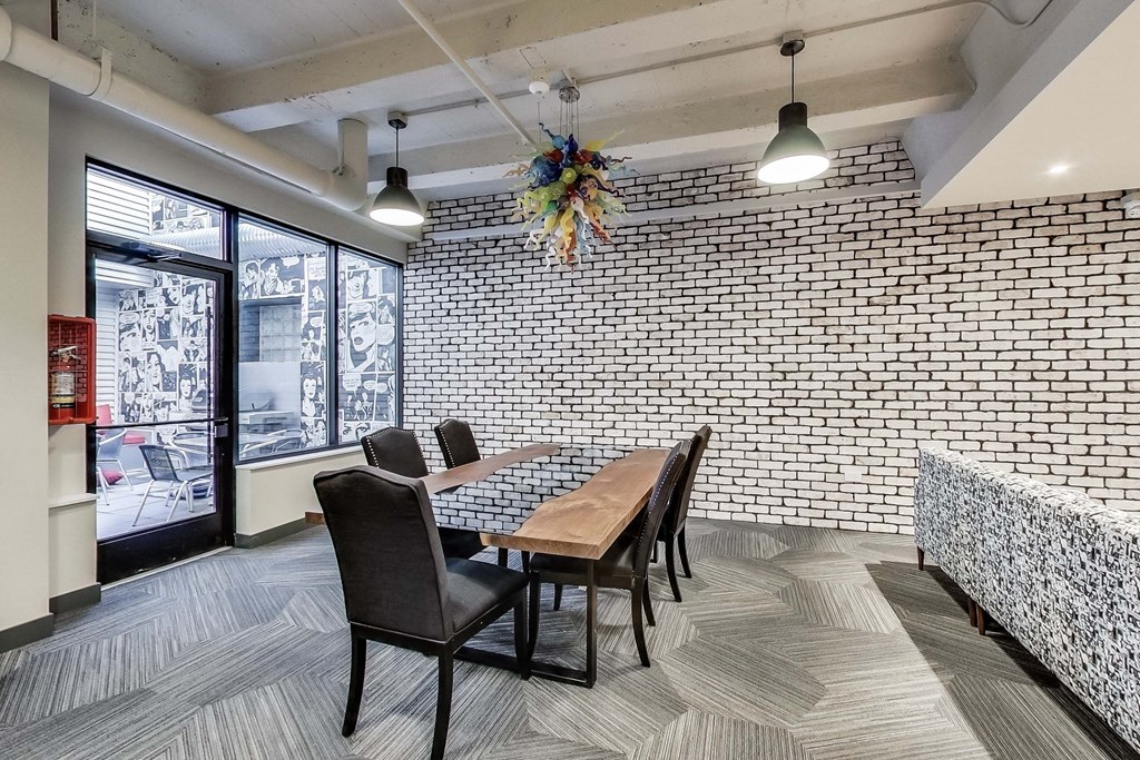 a dining room with a table and chairs and a brick wall