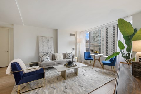 A living room with a blue chair and a grey couch.
