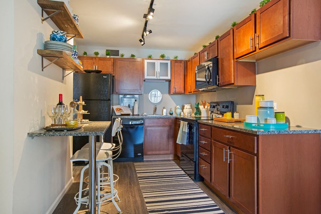 a kitchen with wooden cabinets and a bar with stools