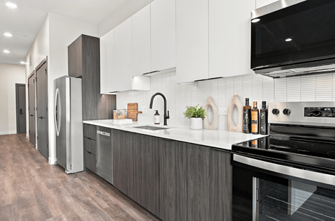 A modern kitchen with a stainless steel refrigerator and oven.