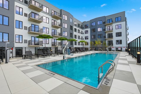 A large indoor swimming pool in front of a multi-story apartment building.