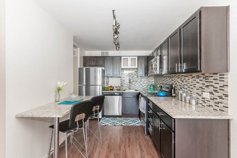 a kitchen with a long counter and a table with chairs