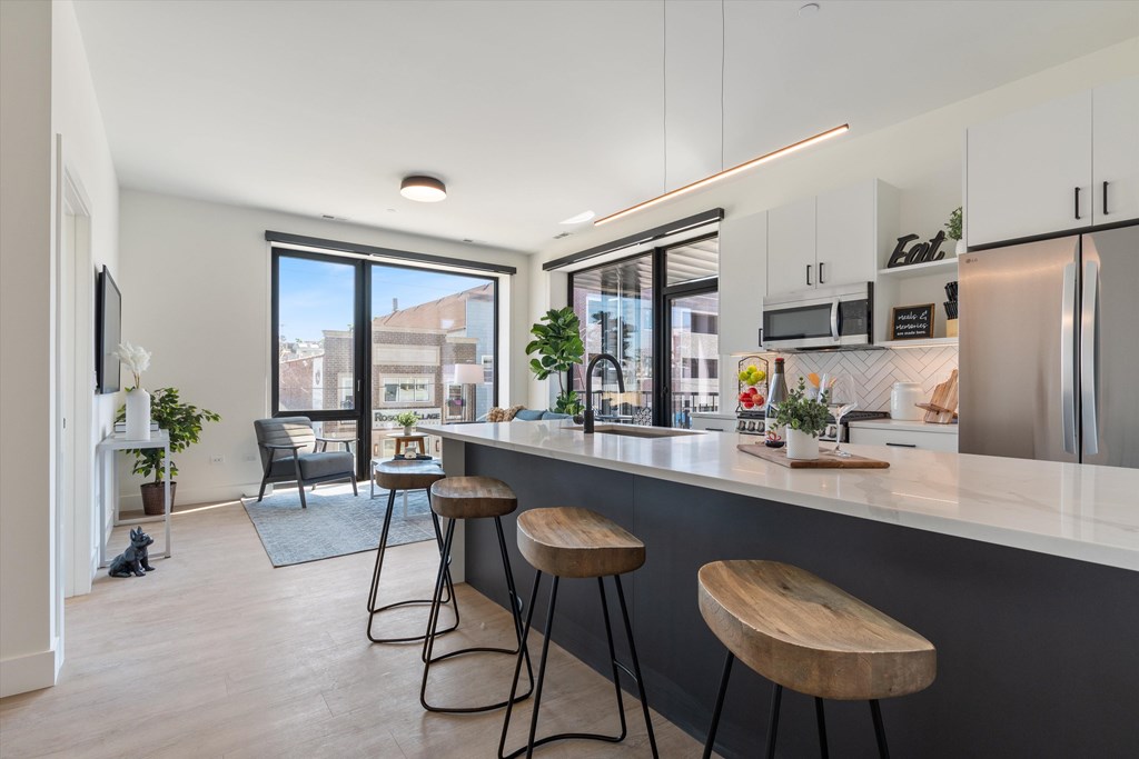 A kitchen with a bar stool and a counter.