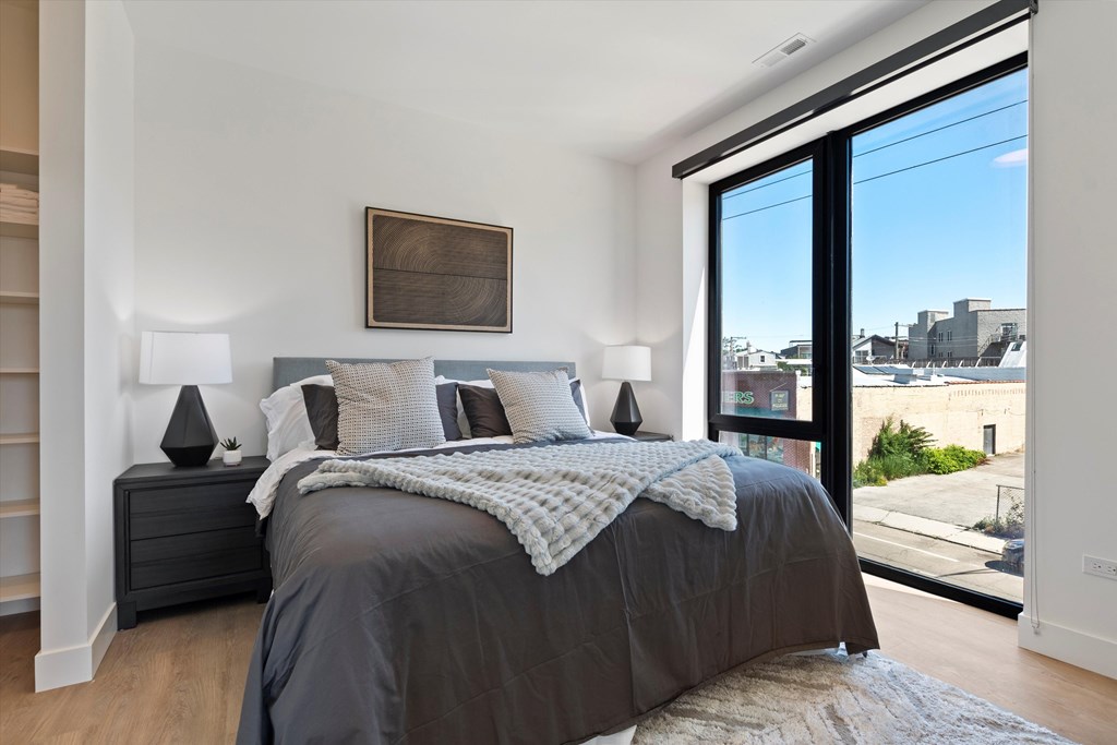 A bedroom with a large bed and a view of the city.