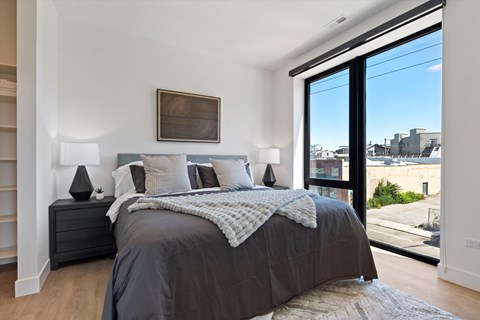 A bedroom with a large bed and a view of the city.