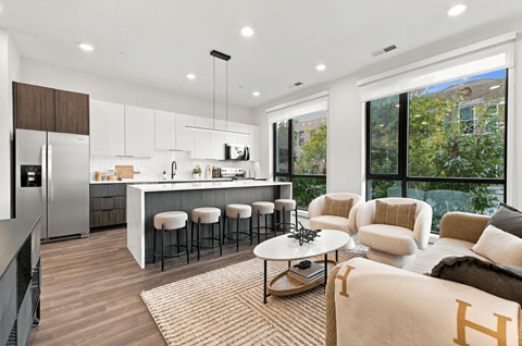 A modern kitchen with a bar area and a living room area.