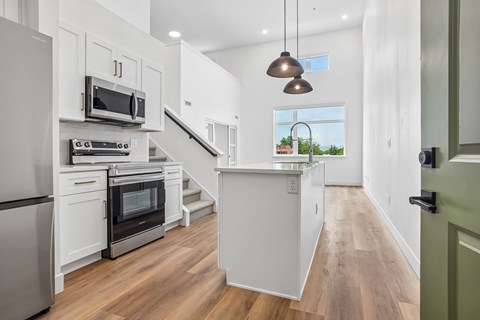 A modern kitchen with white cabinets and stainless steel appliances.