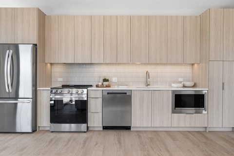 A modern kitchen with wooden cabinets and stainless steel appliances.
