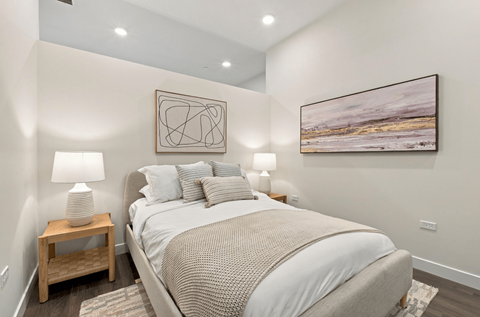 A bedroom with a large bed and a painting on the wall.